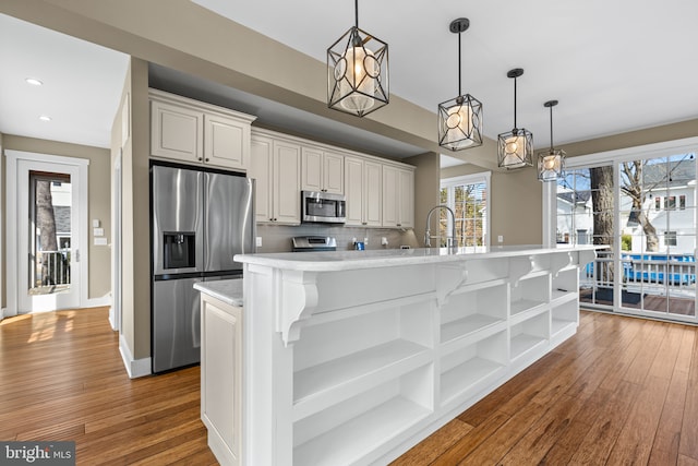 kitchen featuring appliances with stainless steel finishes, light countertops, dark wood-type flooring, and open shelves