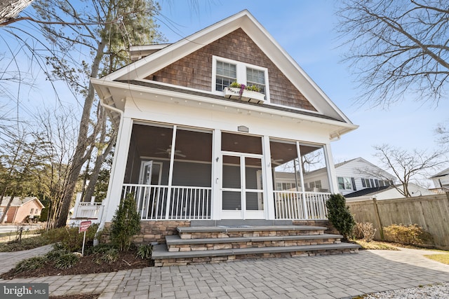 view of front of home featuring fence and a sunroom