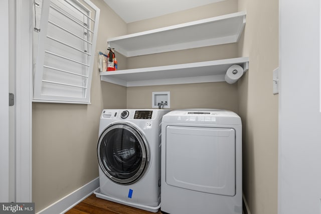 washroom featuring laundry area, dark wood-style floors, washing machine and dryer, and baseboards