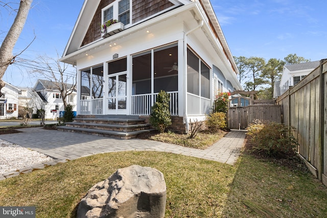 back of house with a lawn, a sunroom, and fence