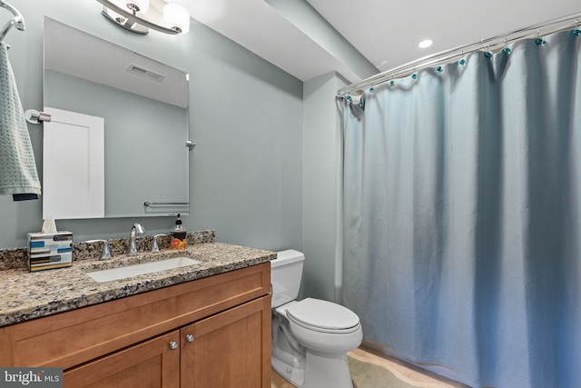 bathroom with visible vents, curtained shower, toilet, and vanity