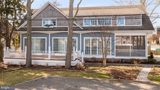 back of house featuring a sunroom and a shingled roof