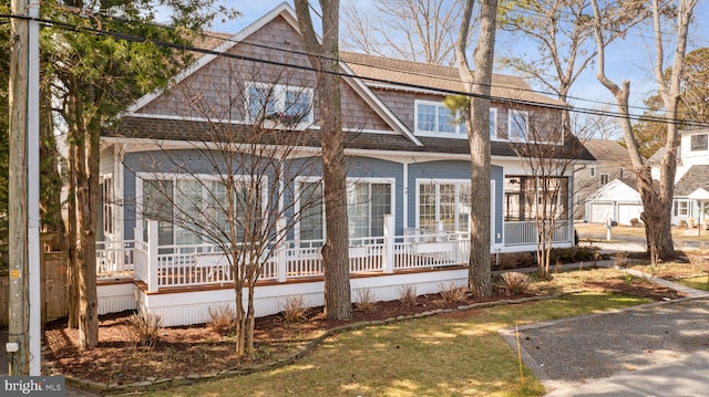 exterior space featuring covered porch and roof with shingles