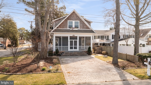 view of front facade featuring fence and a sunroom