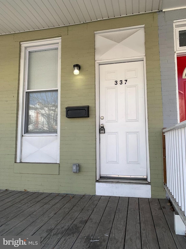 doorway to property featuring brick siding