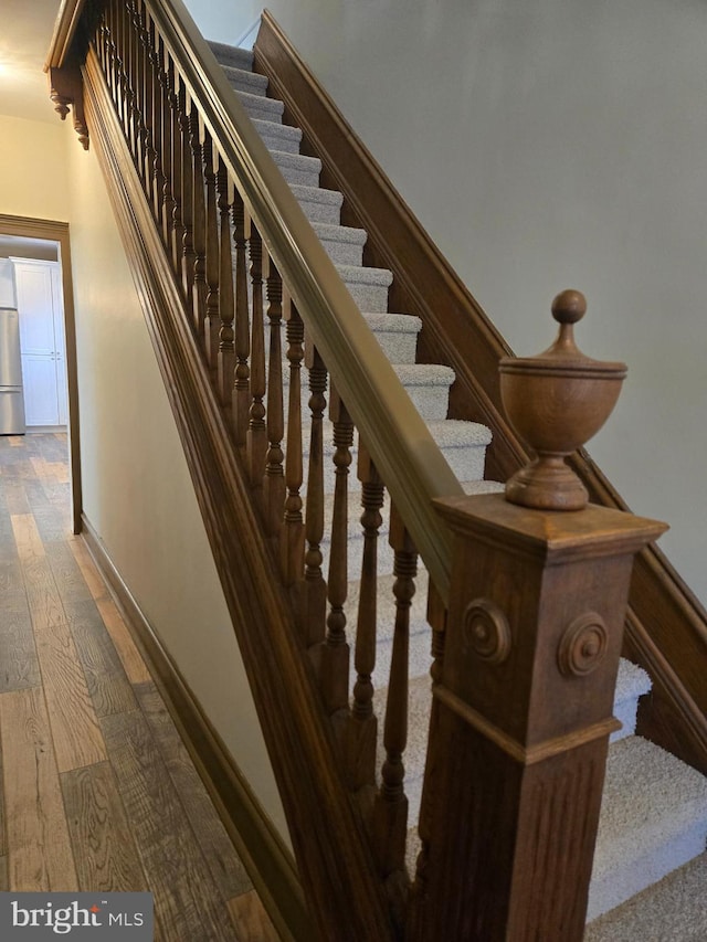 stairs with baseboards and hardwood / wood-style floors