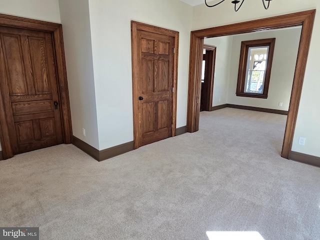 unfurnished bedroom featuring baseboards and light colored carpet