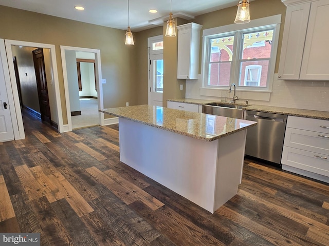 kitchen with dark wood-style flooring, white cabinets, dishwasher, and a sink