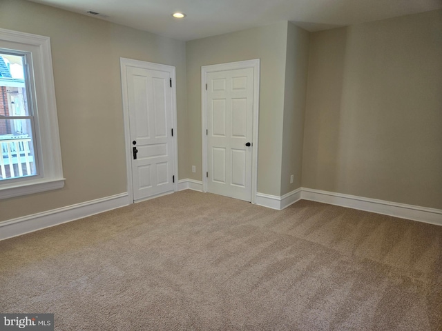 carpeted spare room featuring recessed lighting, baseboards, and visible vents