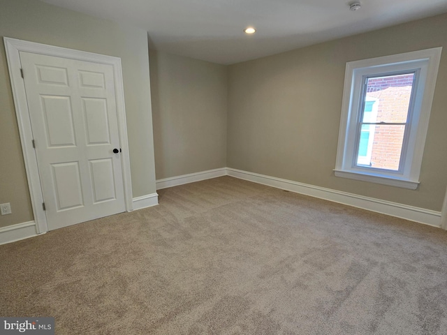 carpeted empty room featuring recessed lighting and baseboards