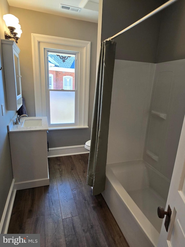 full bath with hardwood / wood-style floors, vanity, visible vents, baseboards, and toilet