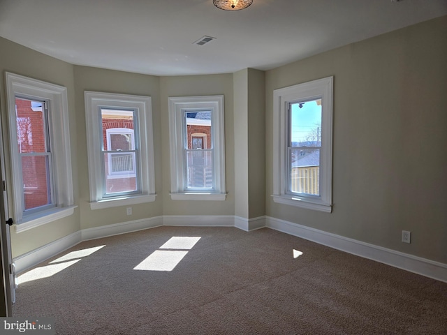 unfurnished room with visible vents, baseboards, and carpet