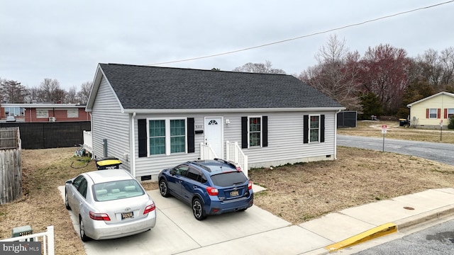 view of front of property featuring crawl space, fence, driveway, and a shingled roof