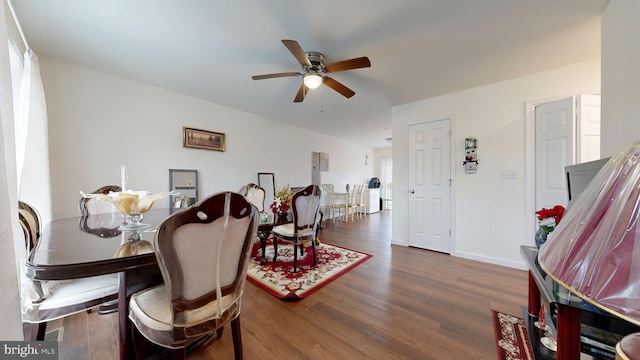 dining space with baseboards, wood finished floors, and a ceiling fan