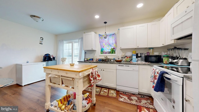 kitchen featuring recessed lighting, white appliances, white cabinetry, and wood finished floors