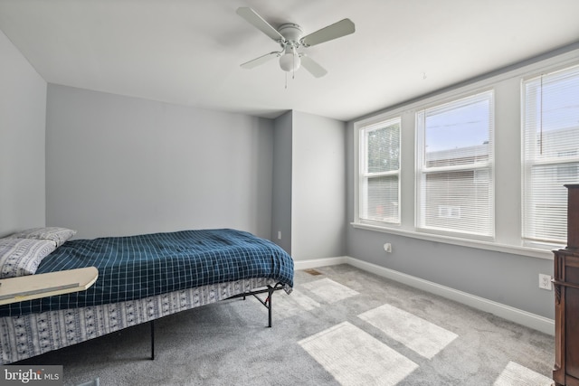 carpeted bedroom with a ceiling fan and baseboards