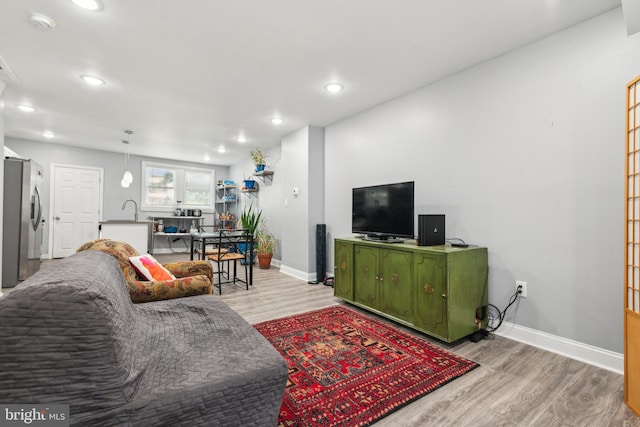 living room featuring recessed lighting, baseboards, and wood finished floors