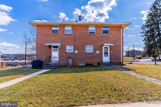 view of front of home featuring brick siding, a front yard, and entry steps