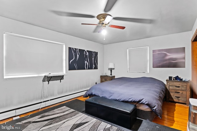 bedroom featuring wood finished floors, ceiling fan, and a baseboard radiator