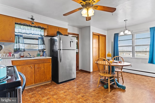 kitchen featuring freestanding refrigerator, a sink, range with electric cooktop, light countertops, and brown cabinets