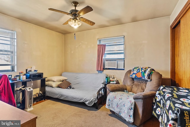 carpeted bedroom featuring cooling unit, a closet, and a ceiling fan