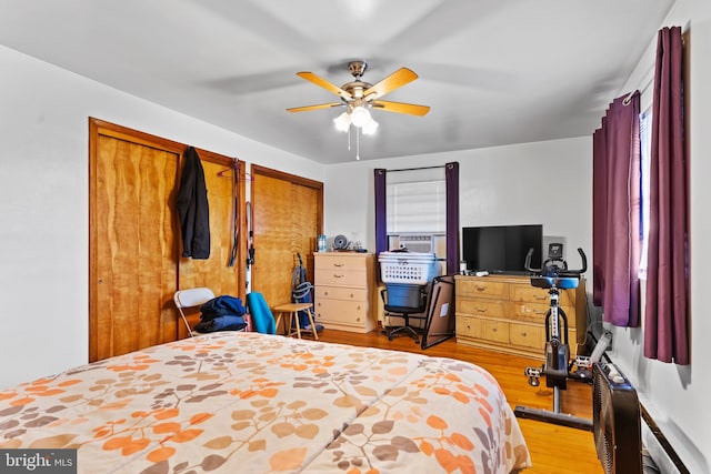 bedroom with multiple closets, a ceiling fan, and light wood finished floors