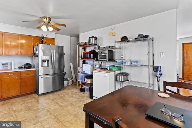 kitchen with ceiling fan, light countertops, stainless steel refrigerator with ice dispenser, fridge, and brown cabinets