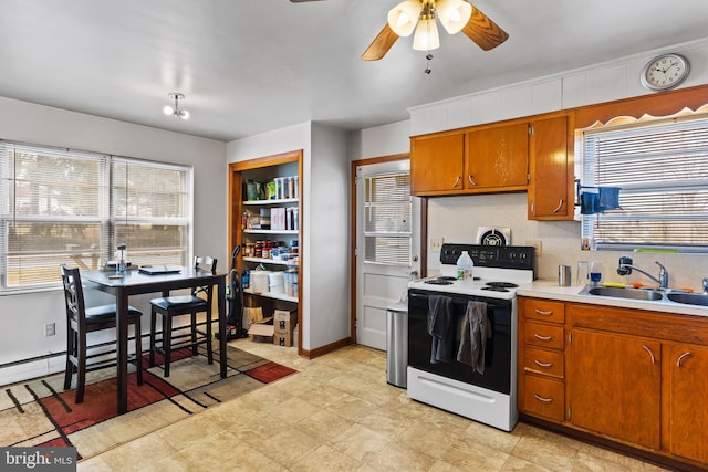 kitchen with white range with electric cooktop, brown cabinetry, light countertops, and a sink