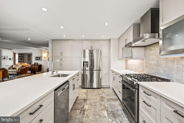 kitchen with a sink, wall chimney range hood, tasteful backsplash, stainless steel appliances, and light countertops