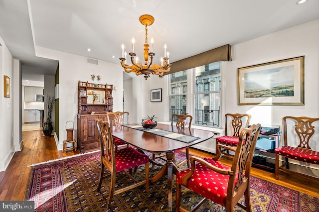 dining space featuring recessed lighting, baseboards, wood-type flooring, and a chandelier