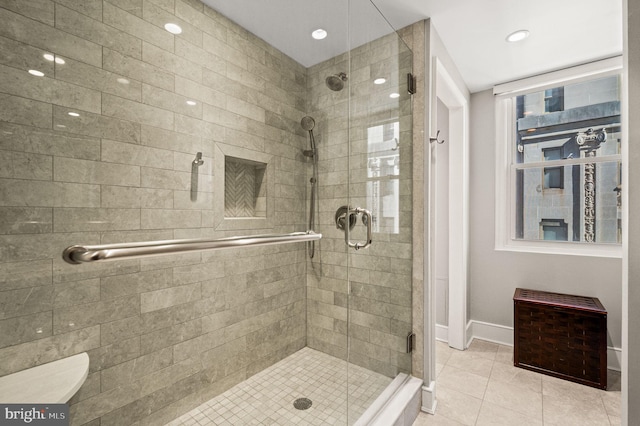 full bath featuring tile patterned floors, a stall shower, and baseboards