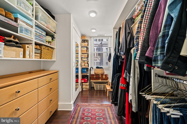 walk in closet with dark wood-type flooring