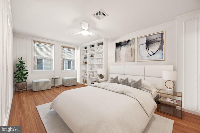 bedroom featuring visible vents, ceiling fan, and wood finished floors