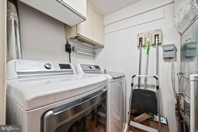 washroom featuring washer and dryer and cabinet space