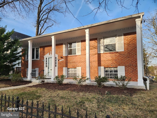 split foyer home with a porch and brick siding