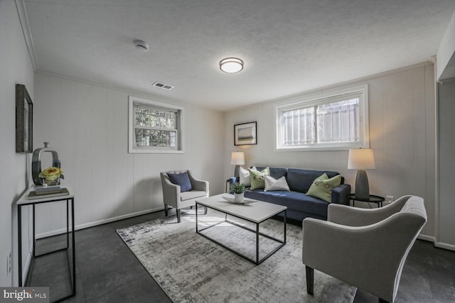 living area featuring ornamental molding, a healthy amount of sunlight, visible vents, and baseboards