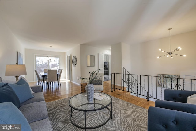 living room with a notable chandelier, wood finished floors, and baseboards