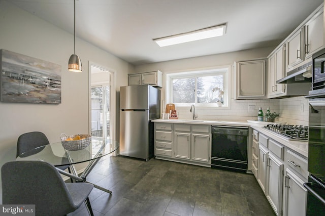 kitchen featuring tasteful backsplash, pendant lighting, light countertops, appliances with stainless steel finishes, and a sink