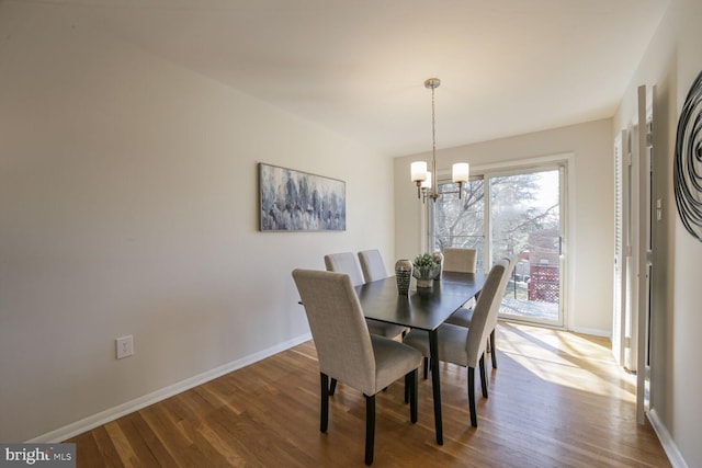 dining space featuring an inviting chandelier, baseboards, and wood finished floors