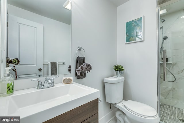 full bath featuring vanity, toilet, baseboards, and a tile shower