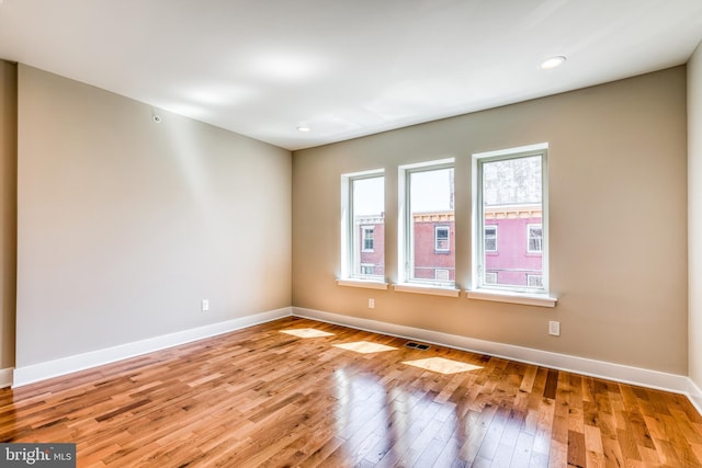 empty room featuring visible vents, recessed lighting, light wood-type flooring, and baseboards