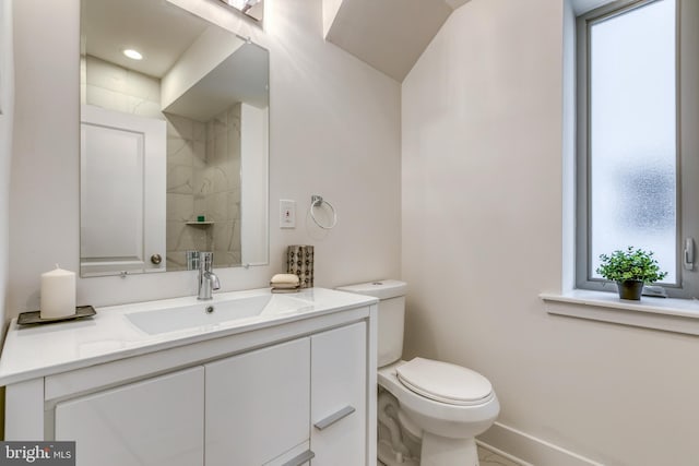 bathroom featuring baseboards, toilet, and vanity