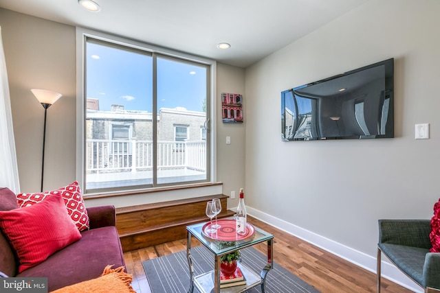 living area with recessed lighting, baseboards, and wood finished floors