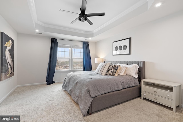 carpeted bedroom featuring baseboards, visible vents, a tray ceiling, ceiling fan, and crown molding