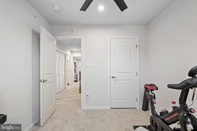 exercise area with a ceiling fan, light colored carpet, visible vents, and baseboards