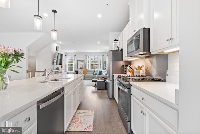 kitchen featuring white cabinetry, wood finished floors, appliances with stainless steel finishes, and a sink