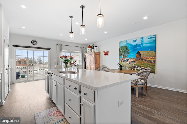 kitchen featuring dishwasher, recessed lighting, wood finished floors, and a sink