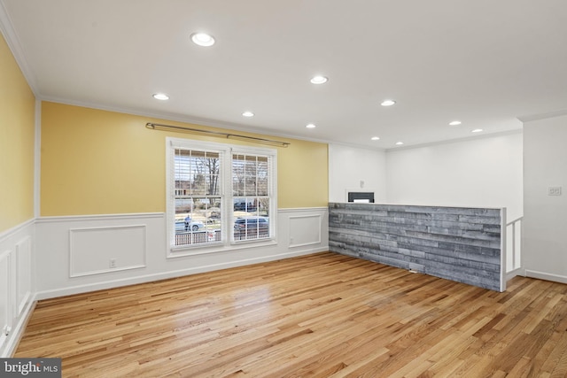 spare room featuring recessed lighting, a wainscoted wall, wood finished floors, and ornamental molding