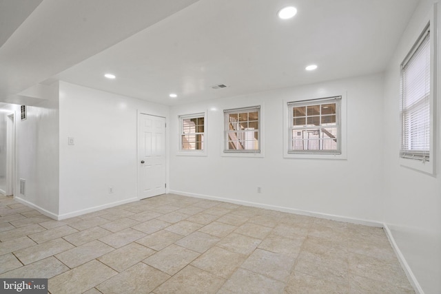 spare room featuring plenty of natural light, recessed lighting, and baseboards