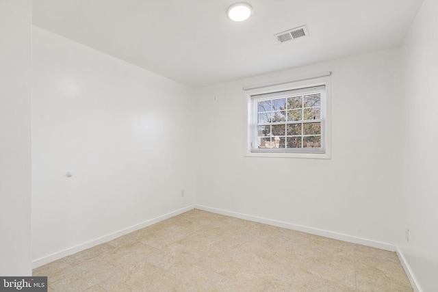 unfurnished room with baseboards and visible vents